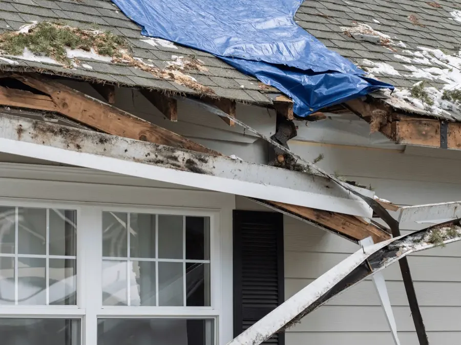 An emergency tarp stretched over a section of roof damaged in a storm