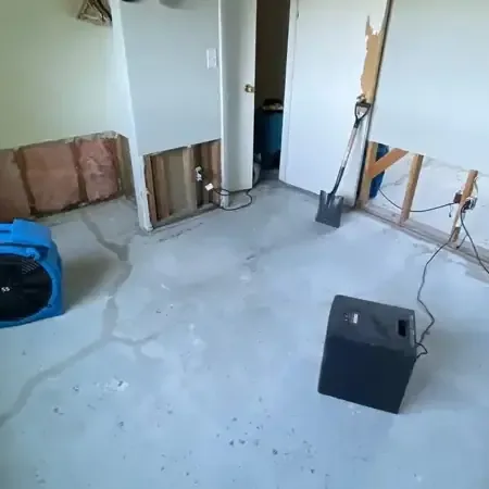 Wet drywall cut open beside a supply pipe in a hallway after a leak inside a house